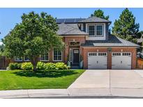 Charming two-story brick home with a well-manicured lawn and a two-car garage at 9583 E Caley Cir, Englewood, CO 80111