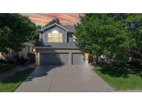 Charming two-story home featuring an attached three-car garage, attractive landscaping, and mature trees enhancing the property's appeal at 9845 Keenan St, Highlands Ranch, CO 80130