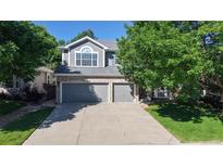 Charming two-story home featuring a two-car garage, brick accents, and well-maintained landscaping with mature trees at 9845 Keenan St, Highlands Ranch, CO 80130