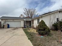 Charming single-story home featuring attached garage and partially xeriscaped front yard at 1021 Downing Way, Denver, CO 80229