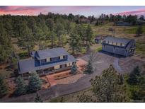 Expansive property featuring a two-story home with a detached garage and scenic treed landscape at 12454 Antelope Trl, Parker, CO 80138