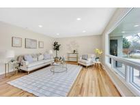 Bright living room features hardwood floors, large windows, comfortable seating, and stylish decor at 2455 E Yale Ave, Denver, CO 80210