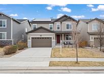 Charming two-story home featuring a neutral color scheme and a well-manicured front yard at 6220 Waterman Way, Frederick, CO 80516