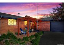 Charming brick home at dusk with a pergola-covered patio and well-maintained landscaping at 421 Iola St, Aurora, CO 80010