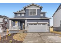 Charming two-story home with a blue exterior, stone accents, and a spacious two car garage at 11030 Snowdon St, Parker, CO 80134