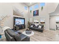 Bright living room boasts high ceilings, stylish decor, large windows, and comfortable seating at 17880 W 94Th Dr, Arvada, CO 80007