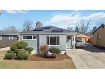 Charming single-story home with light blue siding, solar panels, and a well-manicured front yard at 1040 Florence St, Aurora, CO 80010