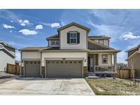 Charming two-story home with a three-car garage and a welcoming front porch at 9466 Quintero St, Commerce City, CO 80022