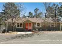 Charming single-story home features a quaint entrance and well-maintained exterior with a gravel drive at 7904 Hill Crest Dr, Louviers, CO 80131