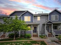 Charming townhome featuring a well-maintained lawn, colorful sky and inviting front entry at 19246 E Carolina Pl # 102, Aurora, CO 80017