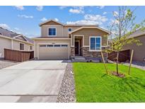 Charming two-story home showcasing a well-manicured lawn and a spacious two-car garage at 19080 E 96Th Pl, Commerce City, CO 80022