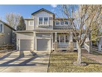 Two-story home with a two-car garage, covered porch, and neutral-colored siding at 16364 Flintlock Ct, Parker, CO 80134