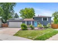 Charming gray two-story home featuring solar panels and a bright blue front door at 9275 W Euclid Ave, Littleton, CO 80123