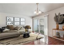 Bright living room features a plush sectional sofa and sliding glass doors to a balcony at 10792 E Exposition Ave # 353, Aurora, CO 80012