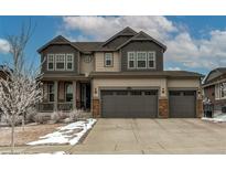 Charming two-story home showcasing a three car garage, covered porch, and beautiful neutral-colored siding at 8204 S Vandriver Way, Aurora, CO 80016