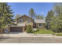 Charming two-story home featuring stone accents, a well-manicured lawn, and mature trees at 1973 S Pitkin St, Aurora, CO 80013