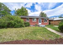 Charming red brick ranch-style home with a well-manicured lawn and mature landscaping at 1646 S Stuart St, Denver, CO 80219
