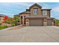 Stunning two-story home with stone accents, three-car garage, and beautiful landscaping at 14022 E Fair Pl, Centennial, CO 80111