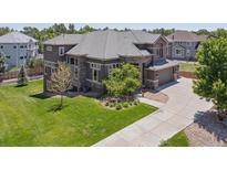 Beautiful exterior elevation of a brown two-story home with landscaped front yard and driveway at 14022 E Fair Pl, Centennial, CO 80111