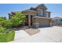 Charming home with stone accents, a well-manicured lawn, and an attached two car garage at 14022 E Fair Pl, Centennial, CO 80111