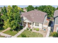Beautiful home with lush landscaping and a well-manicured lawn, surrounded by mature trees at 14230 Lakeview Ln, Broomfield, CO 80023