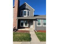 Charming two-story townhome with well-maintained front yard and gray and brick facade under a blue sky at 16901 E Chenango Ave # E, Aurora, CO 80015