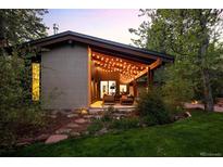 Charming home exterior featuring a covered patio with string lights and lush landscaping at 2060 Hoyt St, Lakewood, CO 80215
