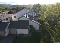 Beautiful exterior view of townhomes with well-maintained lawns and mature trees with mountain views in the background at 8394 S Everett Way # E, Littleton, CO 80128