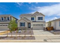 Charming two-story home with neutral siding, stone accents, well-manicured landscaping, and an attached two-car garage at 25234 E Warren Pl, Aurora, CO 80018