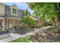 Charming townhouse with brick facade, dormer windows and well-maintained landscaping creating curb appeal at 7557 S Cove Cir, Centennial, CO 80122