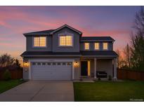 Charming two-story home featuring a well-manicured lawn and an attached two-car garage at 21005 Glacier Park Cv, Parker, CO 80138