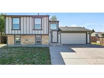 Charming two-story home featuring brick accents, a two-car garage, and a well-maintained front yard at 5202 Dillon St, Denver, CO 80239