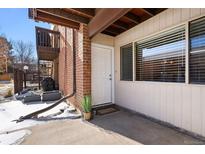 Brick building exterior with private entrance and small patio at 3663 S Sheridan Blvd # 2, Denver, CO 80235