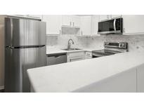 Modern kitchen with stainless steel appliances and white cabinets at 3663 S Sheridan Blvd # 2, Denver, CO 80235