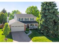 Charming two-story home featuring a manicured lawn, mature trees, and a cozy front porch with great curb appeal at 6829 S Niagara Ct, Centennial, CO 80112