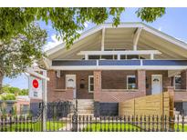 Charming brick home featuring a symmetrical facade, wrought iron fence, and inviting entryway at 3922 W 29Th Ave, Denver, CO 80212