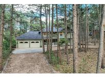 Two-story home with a two-car garage and a front porch surrounded by beautiful trees at 17865 Smugglers Rd, Monument, CO 80132
