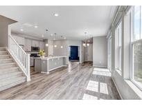Open-concept living space featuring light wood floors, gray accents, and plenty of natural light at 3429 Hardin St, Castle Rock, CO 80109