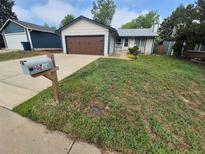 Charming single-story home featuring a well-maintained lawn, attached garage, and inviting entrance at 3735 S Lewiston St, Aurora, CO 80013