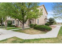 Inviting exterior view of a townhome featuring a well-maintained lawn and attractive stone accents at 12770 Jasmine Ct, Thornton, CO 80602