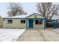 Tan house with blue accents, covered porch, and snow-covered yard at 1770 Akron St, Aurora, CO 80010