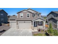 Charming two-story home with a three-car garage, inviting front porch, and neutral-toned exterior at 1953 Morgan Dr, Erie, CO 80516