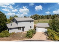 Charming two-story home with a detached garage, mature trees, and a well-manicured front yard at 6502 W 96Th Ave, Westminster, CO 80021