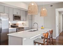 Modern kitchen with stainless steel appliances, white countertops, and pendant lighting at 210 S Cherrywood Dr # 303, Lafayette, CO 80026
