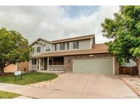 Charming two-story home with stone accents, a well-manicured lawn, and a spacious two-car garage at 11183 E 114Th Ave, Commerce City, CO 80640