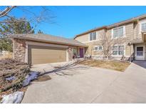 Charming townhome with a two-car garage, stone accents, and a vibrant purple front door at 22029 E Irish Dr, Aurora, CO 80016