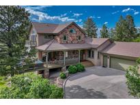 Beautiful home featuring stone accents, large covered porch, and attached two car garage at 5519 Ponderosa Dr, Parker, CO 80134