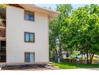 View of the exterior of this condo with well-maintained lawn and established trees at 2201 Sable Blvd # 1003, Aurora, CO 80011