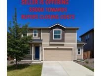 Inviting two-story home featuring a neutral color scheme, well-maintained lawn, and a two-car garage at 2325 Mountain Sky Dr, Fort Lupton, CO 80621
