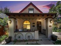 Charming front porch featuring decorative wagon wheels and exterior sconce lighting at 2234 W 35Th Ave, Denver, CO 80211